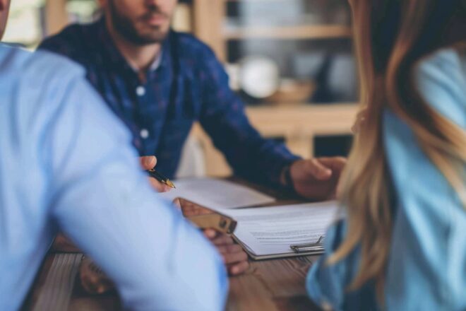 Image d'illustration. Un couple s'apprête à signer un document avec un conseiller
